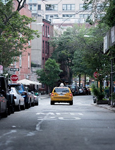 Taxi cab driving down a city street